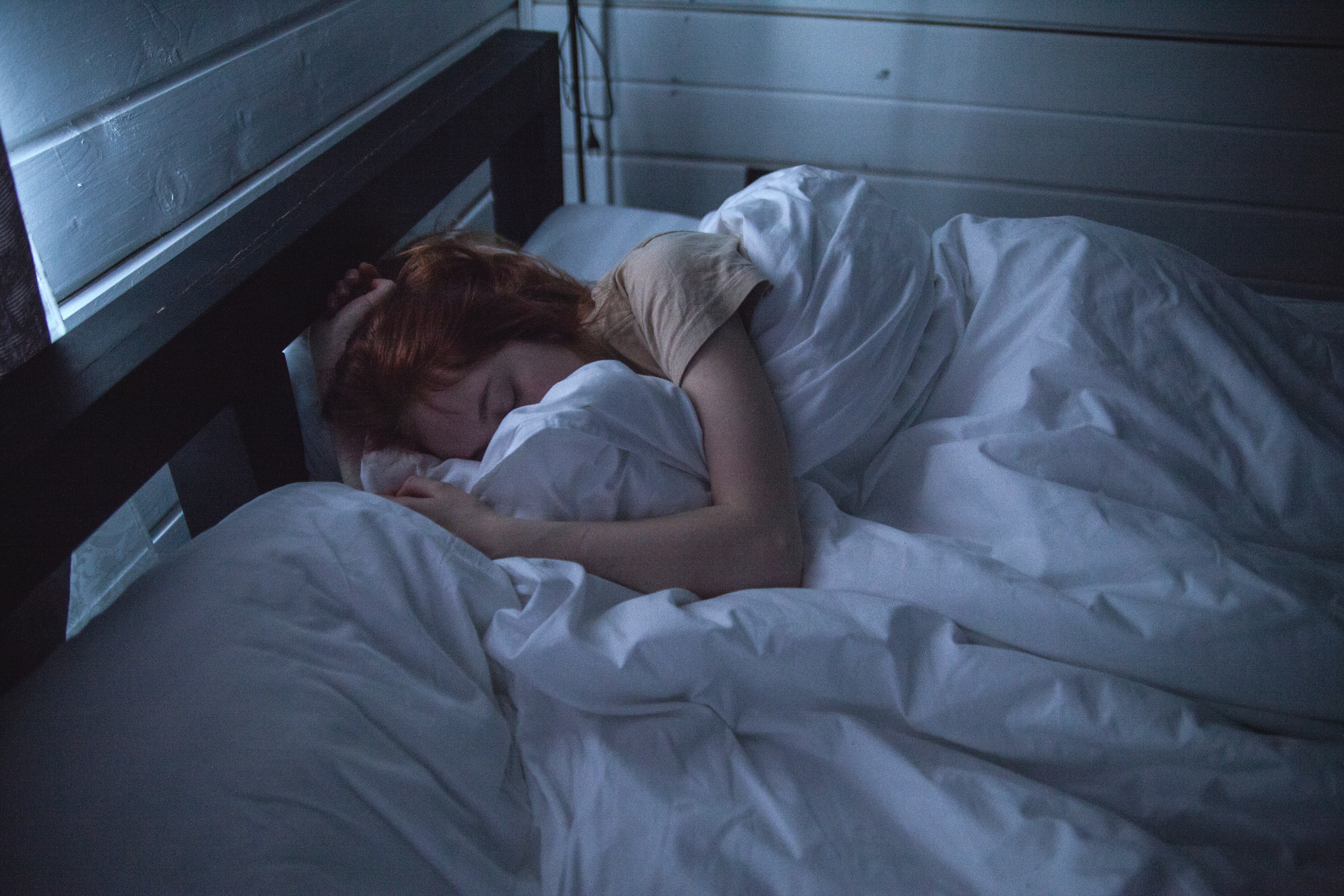 woman-asleep-on-bed-in-dark.jpg