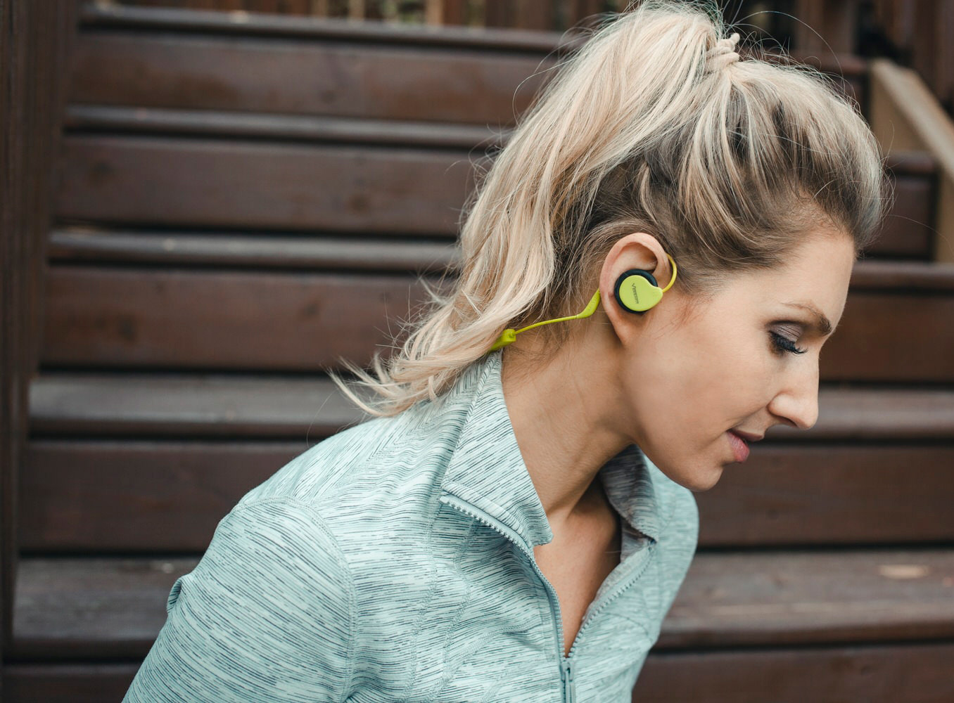 Woman wearing Intrepid Green Versafit Wireless Sport Headphones